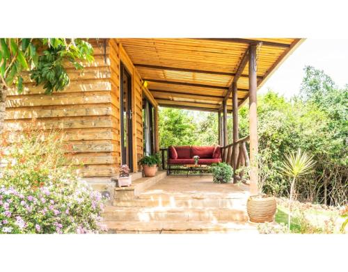 a porch with a red couch on a house at Mua Hills Getaway in Katelembu
