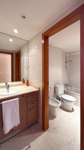 a bathroom with a sink and a toilet and a mirror at M2 Apartament cèntric in Terrassa