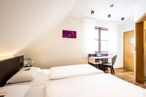 a hotel room with two beds and a desk at Weinhotel Restaurant Klostermühle in Ockfen