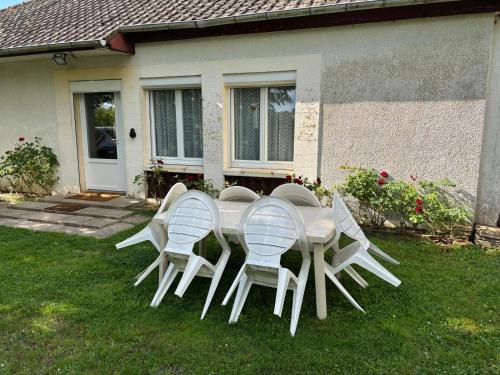 a white table and chairs on the grass in front of a house at Chez Suzanne in Saint-Père-sur-Loire