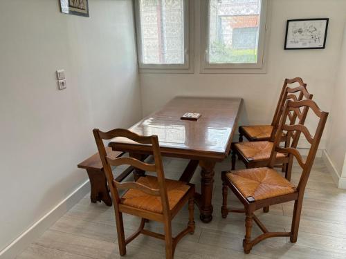 a dining room table with three chairs and a wooden table at Chez Suzanne in Saint-Père-sur-Loire