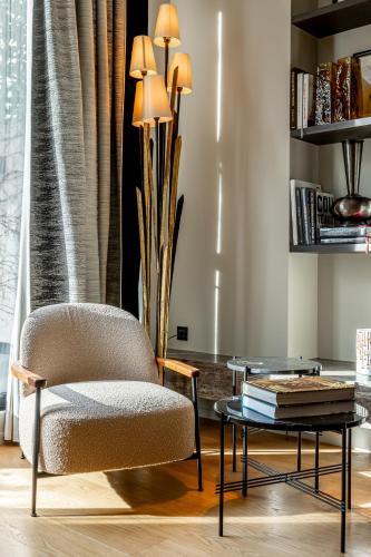 a living room with a chair and a table at Maison Boissière BARNES Residences in Paris