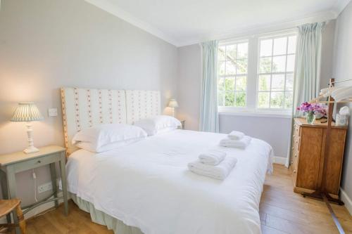 a bedroom with a large white bed with towels on it at Little Fyrish in Evanton