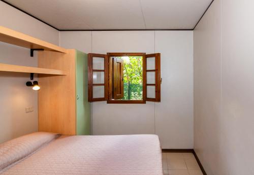 a bedroom with a bed and a window at Camping Europa in Marina di Massa