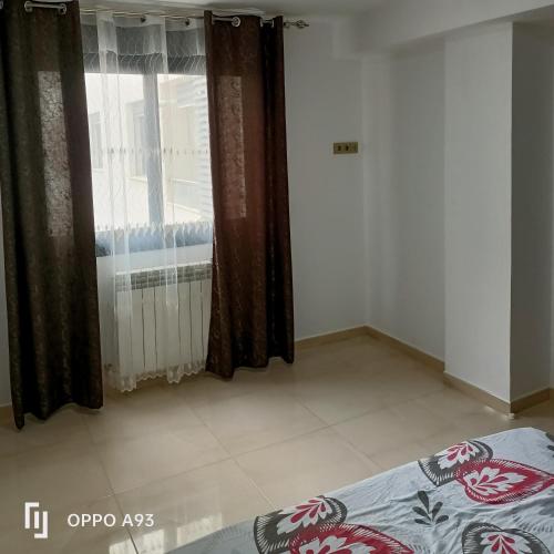 a bedroom with a bed and a window with curtains at Bejaia Amazing T2 in Bejaïa
