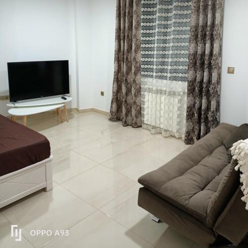 a living room with a couch and a flat screen tv at Bejaia Amazing T2 in Bejaïa
