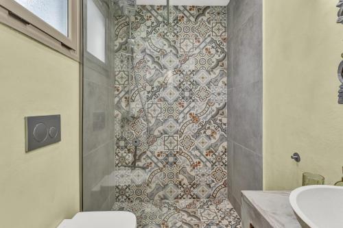 a bathroom with a toilet and a tile shower at Natura Oliva House in Alikanas