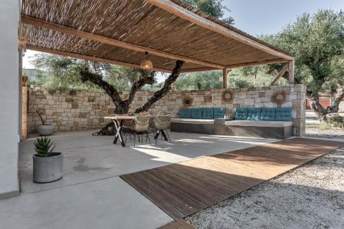 a patio with a table and chairs under a pavilion at Natura Oliva House in Alikanas