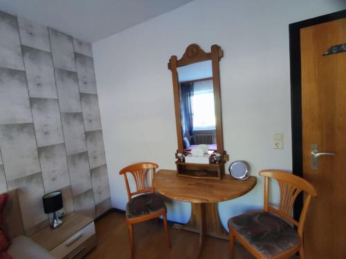 a room with a table and chairs and a mirror at Zum Anker in Briedel