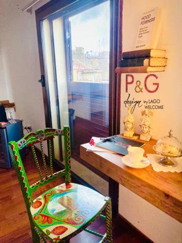a colorful chair sitting next to a wooden table at P&G design by Lago Welcome Enna in Enna