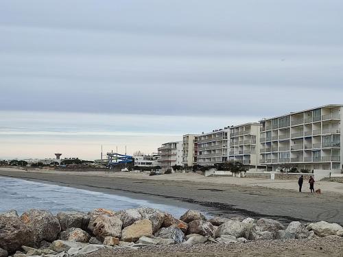 un groupe de bâtiments sur une plage de rochers dans l'établissement T1 dans immeuble sur plage, au Grau-du-Roi