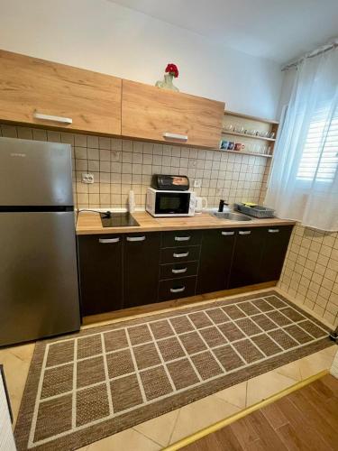 a kitchen with a refrigerator and a microwave at Apartment Rafailovici in Rafailovici