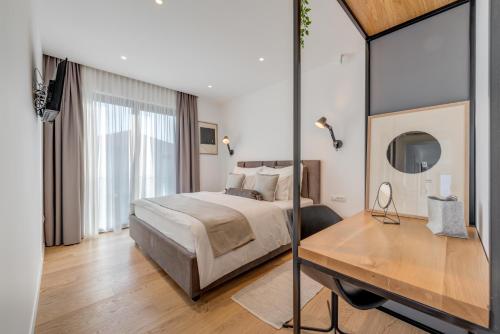 a bedroom with a bed and a desk with a mirror at Villa Juliet in Trogir