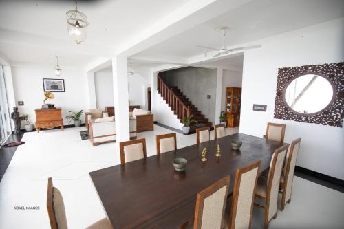 Florain Otium Talpe - 3 Bedroom Oceanfront Villa في يوناواتونا: غرفة طعام مع طاولة وكراسي خشبية