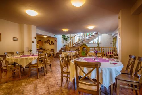 a restaurant with tables and chairs and a staircase at Hotel Villa Siesta in Smokovce