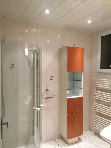 La salle de bains est pourvue d'une douche et d'une télévision murale. dans l'établissement Villa spacieuse Saint-Hernin avec spa convivial, à Saint Hernin