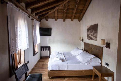 a bedroom with a bed and a table and windows at Vista Boutique Hotel in Berat