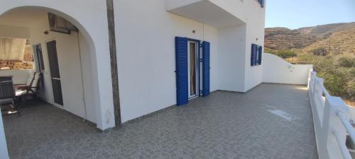 a balcony of a white building with a blue door at Anemi Stay in Kithnos