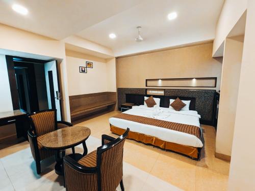 a hotel room with a bed and a table and chairs at Hotel Southern Residency- near to SIPCOT in Kelambākkam