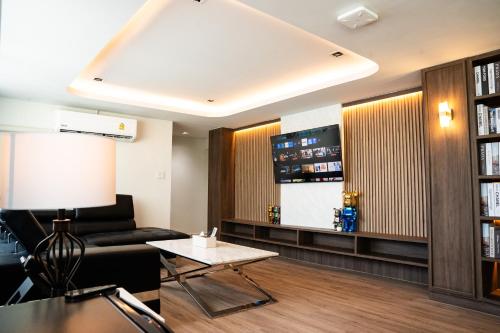 a living room with a couch and a table at indigo Hotel Hatyai in Ban Kohong