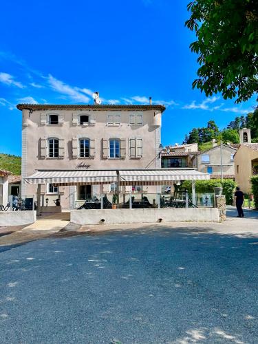 un grand bâtiment au bord d'une rue dans l'établissement Auberge du Bourguet, à Brenon