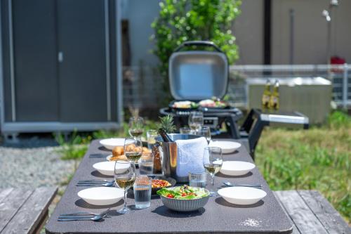 a picnic table with plates of food and glasses of wine at Seaside House Yasutaketei in Shirahama