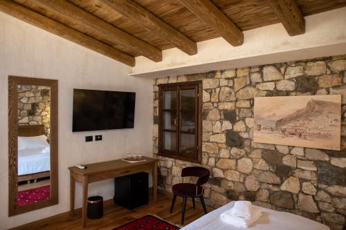 a room with a bed and a desk and a television at Vista Boutique Hotel in Berat