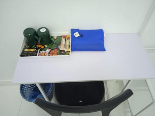 a white table with a black chair next to at Q INN HOTEL Kerteh in Kemaman