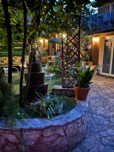 a garden with a fountain and a table and chairs at Hotel Oswaldo in Budapest