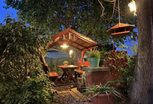 a gazebo with a table and chairs in a garden at Hotel Oswaldo in Budapest