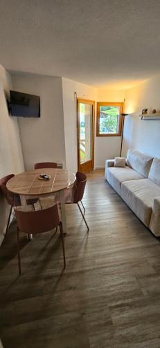 un salon avec un canapé et une table dans l'établissement Appartement - Métabief, à Métabief