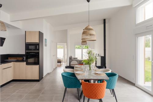 une cuisine et un salon avec une table et des chaises dans l'établissement Villa Acacias - A 5min en voiture de la plage, à Dinard
