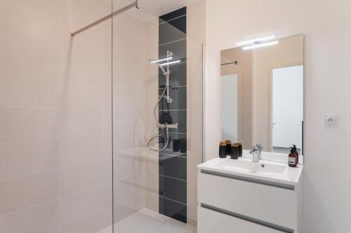 une salle de bain avec douche et lavabo dans l'établissement Villa Acacias - A 5min en voiture de la plage, à Dinard