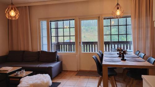 a living room with a table and a couch at Tyylikäs loma-asunto Alppitalossa in Tahkovuori