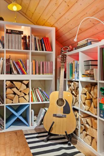 a guitar sitting on a chair in a book shelf at Klara in Sandefjord