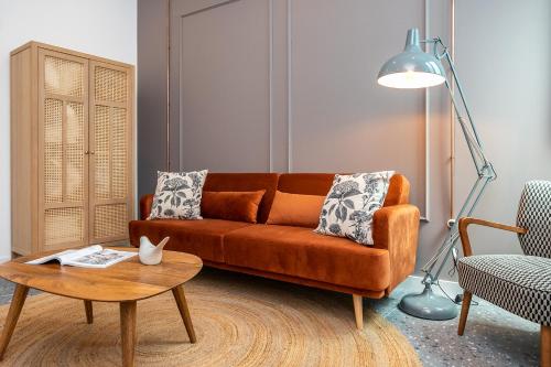 a living room with an orange couch and a table at Dona Simone Boutique Suites & Studios - by @ rita's place in Faro