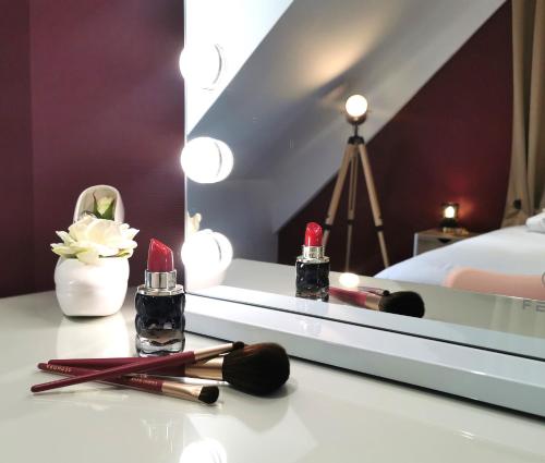 a room with a mirror and cosmetics on a table at Le Scénario - centre ville in Sarreguemines