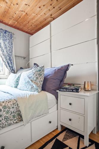 a bedroom with a white bed and a night stand at Klara in Sandefjord
