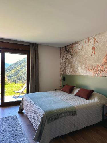 a bedroom with a bed and a large window at BOJ Casas de Montaña in Bielsa
