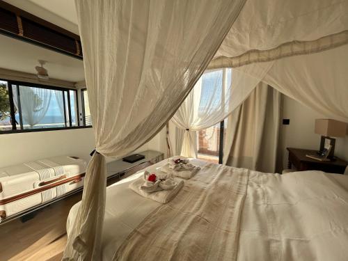 a bedroom with a white bed with a canopy at le lodge Saint Clair in Sète