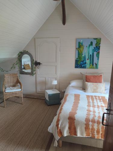 une chambre avec un lit et une chaise dans l'établissement Le clos champêtre, à Longué