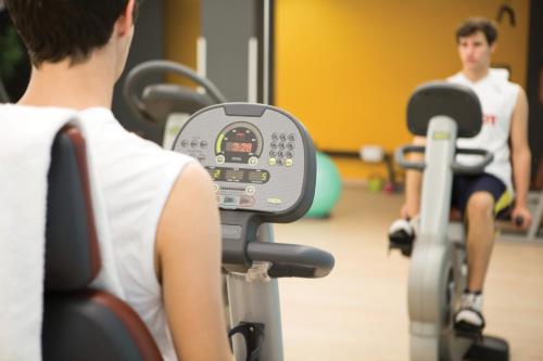 a man riding on an exercise bike in a gym at Best Western Plus Hotel Expo in Villafranca di Verona