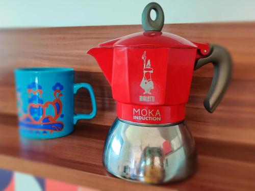 a red coffee maker sitting next to a blue mug at Wellness- HotTub & Sauna- Pet Friendly- Hiking in Keutschach am See