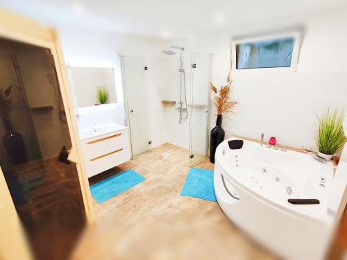 a bathroom with a white tub and a sink at Wellness- HotTub & Sauna- Pet Friendly- Hiking in Keutschach am See