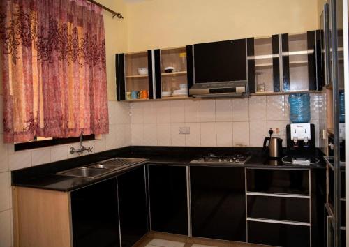 una piccola cucina con lavello e microonde di Keys to Paradise Sapphire 5 Nextgen a Nairobi