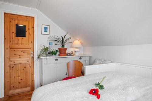 a bedroom with a bed with a red flower on it at Klara in Sandefjord