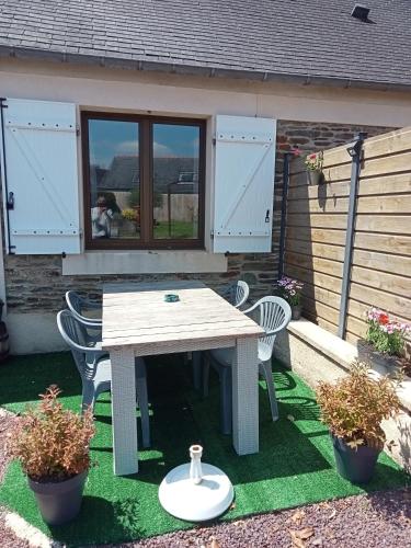 a picnic table and two chairs in front of a house at Gîte du Kreizker in Cléden-Poher