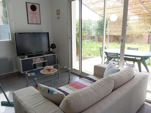 a living room with a couch and a tv at Villa proche mer Ollioules-Sanary in Ollioules