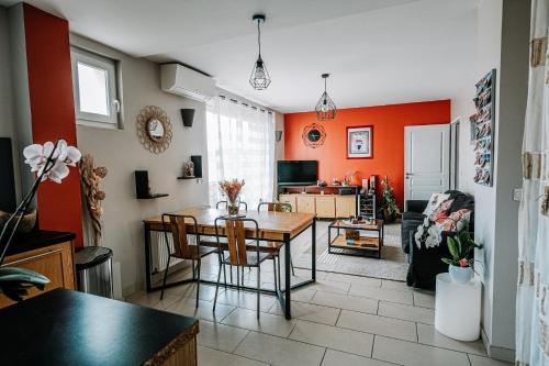 - un salon avec des murs orange, une table et des chaises dans l'établissement T3 Cosy et lumineux avec garage à 2 pas du centre !, à Nîmes
