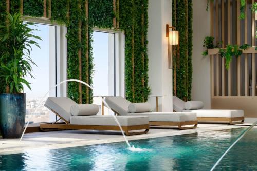a hotel lobby with a pool and chairs and plants at Ramada by Wyndham Riyadh King Fahd Road in Riyadh